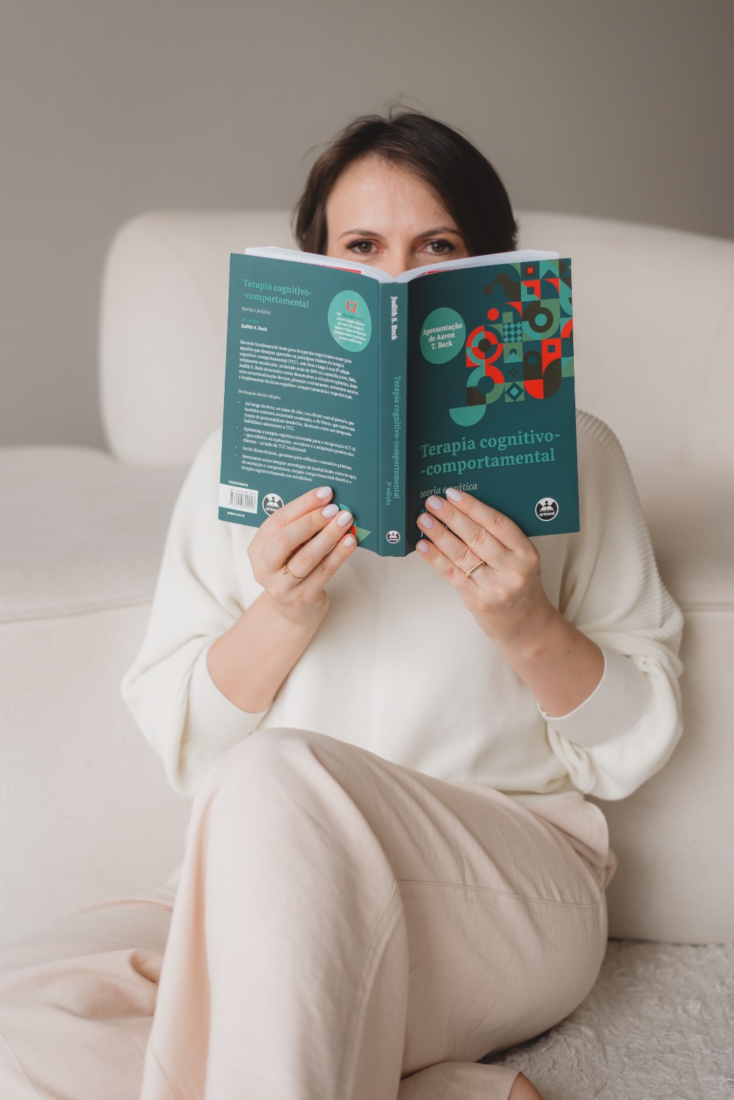 Karla Tomiello lendo um livro de Terapia Cognitivo-Comportamental